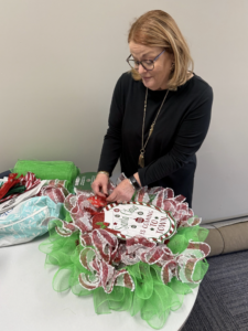 Susan Moore puts the finishing touches on her bright green and red wreath, one she created at the RCC Holiday Craft Fair.